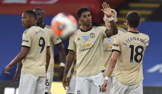 Manchester United&#x27;s Marcus Rashford, center, celebrates after scoring the opening goal during the English Premier League soccer match between Crystal Palace and Manchester United at Selhurst Park in London, England, Thursday, July 16, 2020. (AP Photo/Glyn Kirk, Pool)