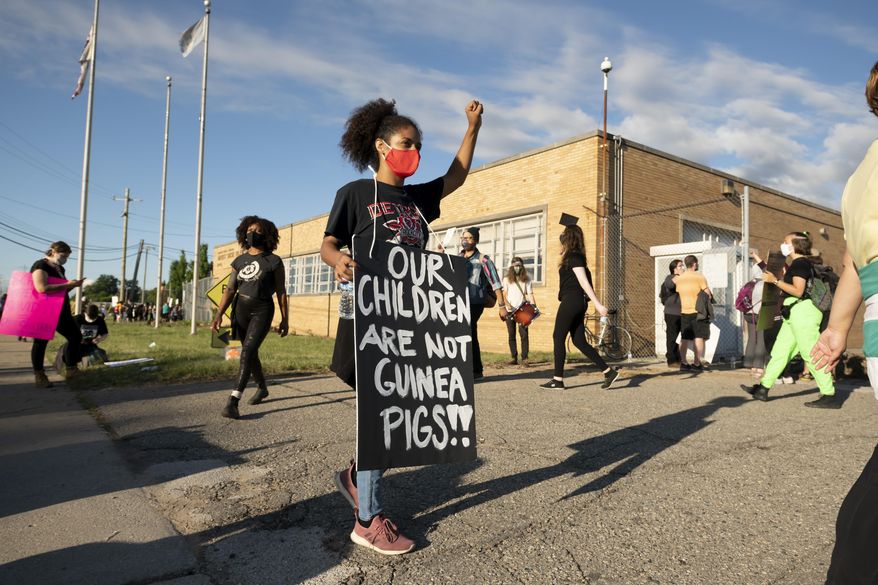 Demonstrators block the driveways of the Detroit Public Schools West Side Bus Terminal to keep school buses from running on the first day of summer school, in Detroit, Monday, July 13, 2020. Concerns about COVID-19 and a lack of safety measures prompted the protesters to demand that schools close. (David Guralnick/The Detroit News)/Detroit News via AP)