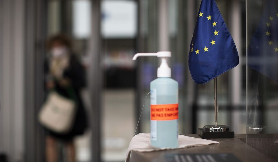 A bottle of hand sanitizer stands next to an EU flag at the entrance to the European Council building in Brussels, Thursday, July 16, 2020. On Friday, July 17, 2020, leaders from the 27 European Union nations will meet face-to-face to try to carve up a potential package of 1.85 trillion euros among themselves. Due to coronavirus concerns, Friday&#x27;s summit will be held in a larger-than-usual meeting room to meet social distancing requirements, the media will be kept to a minimum and there will be no group photo of the leaders. (AP Photo/Francisco Seco)