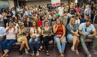 Angry residents react when the Utah County Commission meeting was adjourned before it even started, Wednesday, July 15, 2020, in Provo, Utah. The group protesting against face masks being required in schools removed the social distancing tape on the chairs and filled the Utah County Commission room to over flowing, prompting Commissioner Tanner Ainge to call for a vote to adjourn the meeting. (Rick Egan/The Salt Lake Tribune via AP)