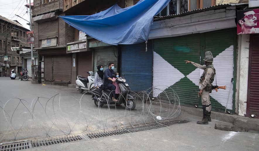 An Indian paramilitary soldier asks civilians to take an alternative road during lockdown to stop the spread of the coronavirus in Srinagar, Indian controlled Kashmir, Friday, July 17, 2020.India crossed 1 million coronavirus cases on Friday, third only to the United States and Brazil, prompting concerns about its readiness to confront an inevitable surge that could overwhelm hospitals and test the country’s feeble health care system. (AP Photo/Mukhtar Khan) **FILE**
