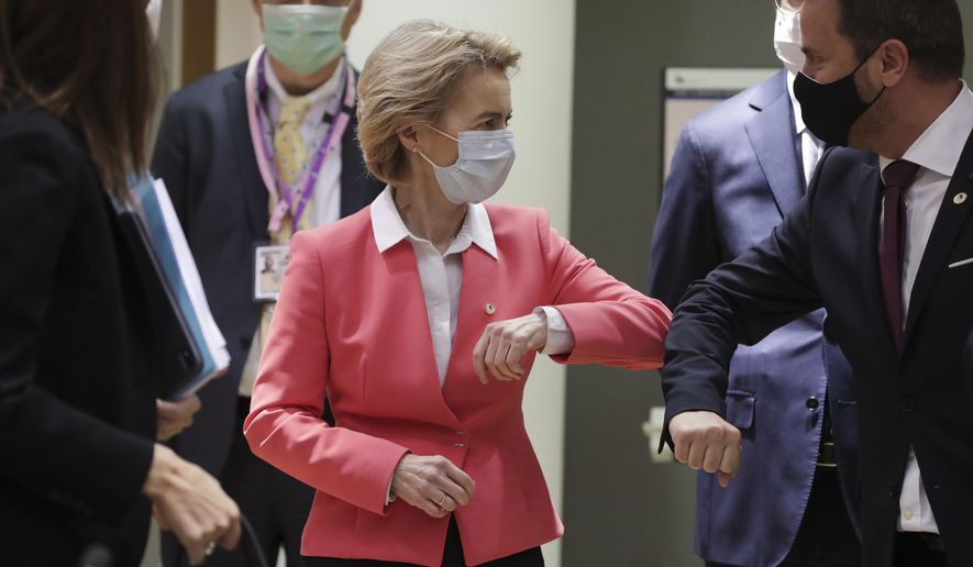 European Commission President Ursula von der Leyen, left, greets Luxembourg's Prime Minister Xavier Bettel with an elbow bump during a round table meeting at an EU summit in Brussels, Friday, July 17, 2020. Leaders from 27 European Union nations meet face-to-face on Friday for the first time since February, despite the dangers of the coronavirus pandemic, to assess an overall budget and recovery package spread over seven years estimated at some 1.75 trillion to 1.85 trillion euros. (Stephanie Lecocq, Pool Photo via AP)