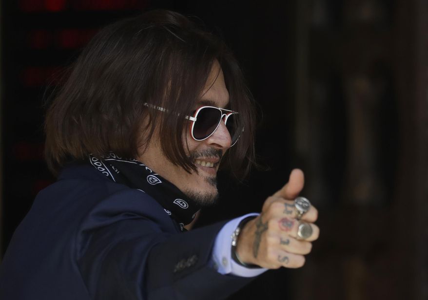 Actor Johnny Depp gestures as he arrives at the High Court in London, Friday, July 17, 2020. Depp is suing News Group Newspapers, publisher of The Sun, and the paper&#39;s executive editor, Dan Wootton, over an April 2018 article that called him a &amp;quot;wife-beater.&amp;quot; The Sun&#39;s defense relies on a total of 14 allegations by his ex-wife Amber Heard of Depp&#39;s violence. He strongly denies all of them. (AP Photo/Kirsty Wigglesworth)