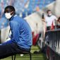 A ball carrier wears a face mask prior to the friendly soccer match between Paris Saint Germain and Le Havre, in Le Havre, western France, Sunday, July 12, 2020. For the first time since the coronavirus shut down sports and chased away spectators, Neymar, Kylian Mbappe and other soccer stars are going to play again in front of fans. (AP Photo/Thibault Camus)