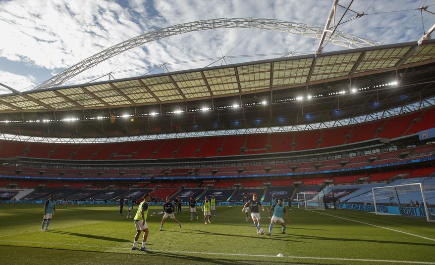 Manchester City players warm up ahead of the FA Cup semifinal soccer match between Arsenal and Manchester City at Wembley in London, England, Saturday, July 18, 2020. (AP Photo/Matt Childs,Pool)