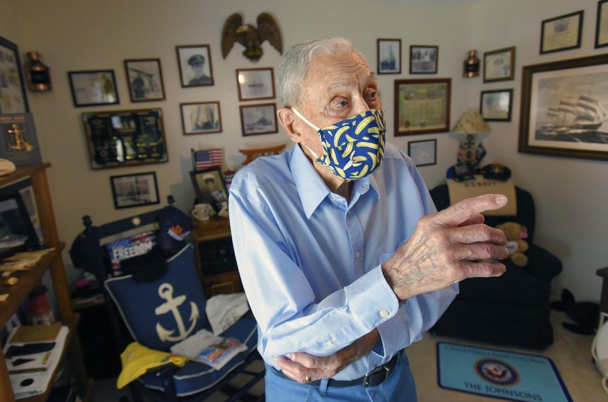 100 year old Bob Johnson gestures in the room of his home that contains photographs and mementos from his 20 year career in the U.S. Navy and his Antarctic explorations with Admiral Richard Byrd Tuesday, July 7, 2020 in Jacksonville, Fla. Robert Johnson, who turned 100 on Tuesday, a hot and sunny Florida day, barely hesitated when asked what he’d do if given another chance to go to Antarctica, the land of eternal ice and snow that he first journeyed to as a teenager. (Bob Self/The Florida Times-Union via AP)