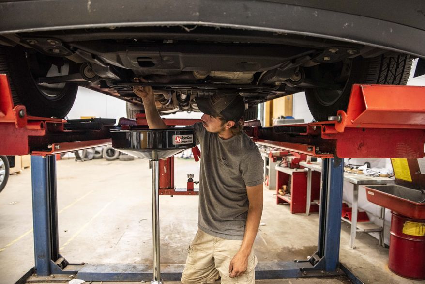 Chris Wilkerson changes the oil in a vehicle during the automotive technology course at Appomattox County High School in Appomattox, Va., on Wednesday, July 8, 2020. (Kendall Warner/The News & Advance via AP)