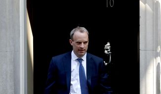 FILE - In this Wednesday April 22, 2020 file photo, Britain&#39;s Foreign Secretary Dominic Raab leaves 10 Downing Street, London. Britain’s foreign secretary hinted Sunday, July 19 he may move to suspend the U.K.’s extradition arrangements with Hong Kong, and accused Beijing of “gross and egregious” human rights abuses against its Uighur population in China’s western province of Xinjiang. (AP Photo/Frank Augstein, file)