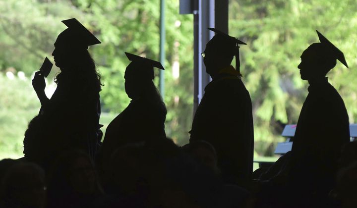 In this Friday, June 1, 2018, file photo, graduates are silhouetted against the green landscape as they line up to receive their diplomas at Berkshire Community College&#x27;s commencement exercises at the Shed at Tanglewood in Lenox, Mass. (Gillian Jones/The Berkshire Eagle via AP, File)