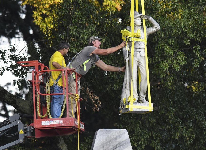 The Confederate statue located in the Circle at the University of Mississippi is lowered to the ground as part of the process to move it to the Confederate Soldiers Cemetery on campus in Oxford, Miss. Tuesday, July 14, 2020.  (AP Photo/Bruce Newman) ** FILE **