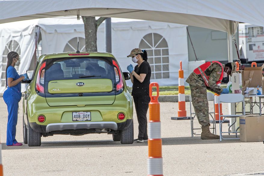 People line up at the Covid-19 testing site at the Southern University's FG Clark parking lot, Tuesday July 7, 2020, in Baton Rouge, La. (Bill Feig/The Advocate via AP)