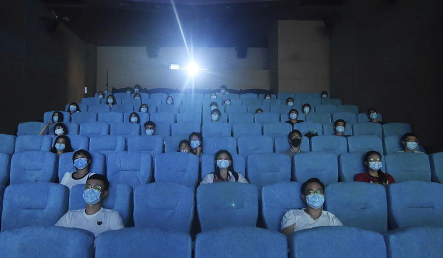 Movie-goers wearing masks to protect themselves from the coronavirus are spaced apart as they watch a movie in a newly reopened cinema in Hangzhou in eastern China's Zhejiang province on Monday, July 20, 2020. China is going back to the movies. Following months of closure, limited numbers of movie goers were allowed back Monday in cities where the risk of virus infection is considered low. (Chinatopix via AP)