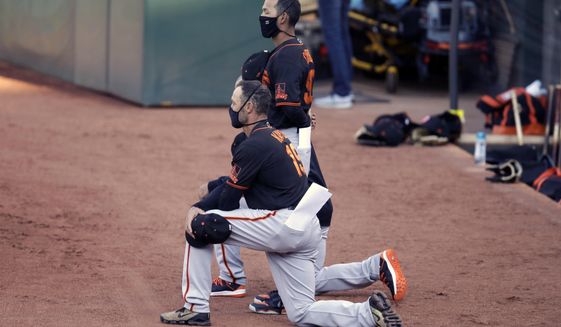 San Francisco Giants&#39; manager Gabe Kapler kneels during the national anthem prior to an exhibition baseball game against the Oakland Athletics, Monday, July 20, 2020, in Oakland, Calif. (AP Photo/Ben Margot)