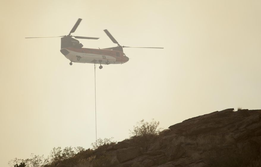 Fire crews with a helicopter from around Washington County fight a wildfire near Leeds, Utah. Sunday, July 19, 2020. (Chris Caldwell/The Spectrum via AP)