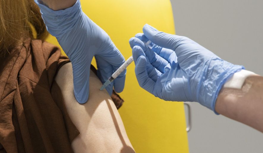 In this handout photo released by the University of Oxford a volunteer participates in the vaccine trial in Oxford, England on July 7, 2020. Scientists at Oxford University say their experimental coronavirus vaccine has been shown in an early trial to prompt a protective immune response in hundreds of people who got the shot. In research published Monday July 20, 2020 in the journal Lancet, scientists said that they found their experimental COVID-19 vaccine produced a dual immune response in people aged 18 to 55. (University of Oxford via AP)
