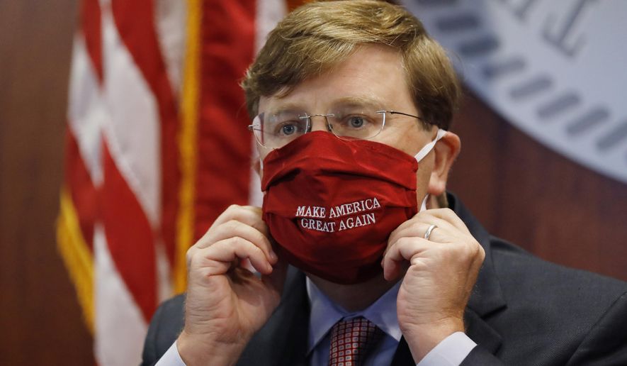 Mississippi Gov. Tate Reeves adjusts his &amp;quot;Make America Great Again,&amp;quot; face mask upon concluding his press briefing with members of the state&#39;s COVID-19 response team, to discuss the ongoing strategy to reduce and limit transmission, Monday, July 20, 2020, in Jackson, Miss. (AP Photo/Rogelio V. Solis)