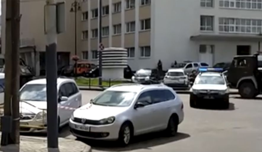 In this image take from video, the scene as police close off the streets, after an armed man seized a bus and took some 20 people hostage in the city centre of Lutsk, some 400 kilometers (250 miles) west of Kyiv, Ukraine on Tuesday July 21, 2020.  The assailant is armed and carrying explosives, according to a Facebook statement by Ukrainian police. Police officers are trying to get in touch with the man and they have sealed off the area. (AP Photo)