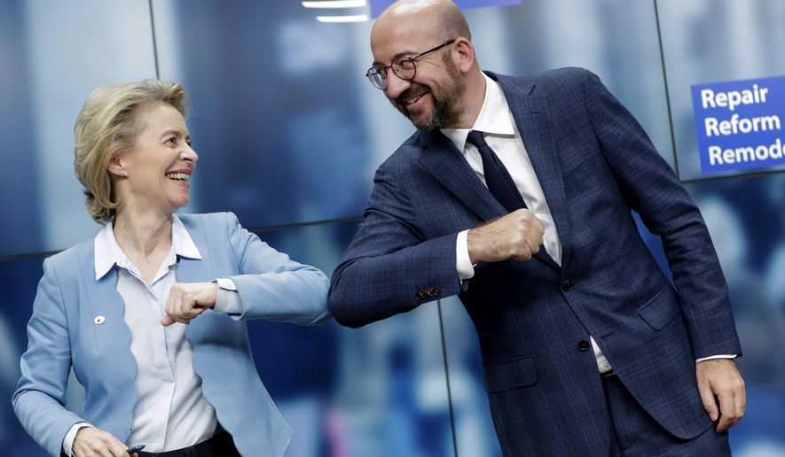 European Commission President Ursula von der Leyen, left, and European Council President Charles Michel bump elbows after addressing a media conference at an EU summit in Brussels, Tuesday, July 21, 2020. Weary European Union leaders finally clinched an unprecedented budget and coronavirus recovery fund early Tuesday, finding unity after four days and as many nights of fighting and wrangling over money and power in one of their longest summits ever. (Stephanie Lecocq, Pool Photo via AP)