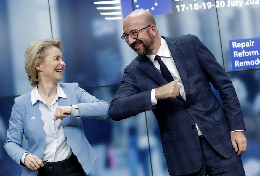 European Commission President Ursula von der Leyen, left, and European Council President Charles Michel bump elbows after addressing a media conference at an EU summit in Brussels, Tuesday, July 21, 2020. Weary European Union leaders finally clinched an unprecedented budget and coronavirus recovery fund early Tuesday, finding unity after four days and as many nights of fighting and wrangling over money and power in one of their longest summits ever. (Stephanie Lecocq, Pool Photo via AP)
