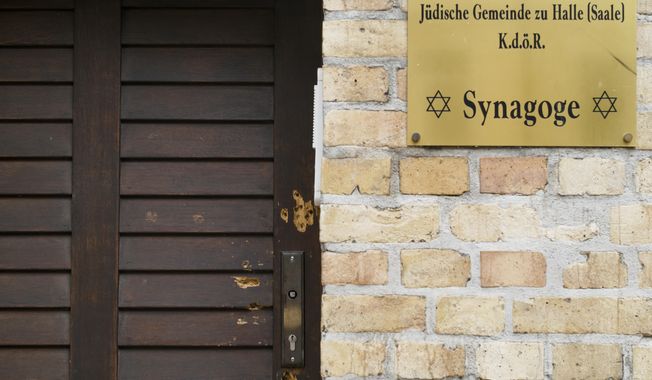 Bullet holes are still visible in the wooden door of the synagogue in Halle, Germany, Monday, July 20, 2020. The trial of a heavily armed attacker who wanted to force his way into the synagogue begins on Tuesday, July 21, 2019 in Magdeburg. After not entering the synagogue, the man shot two passers-by.(AP Photo/Markus Schreiber)