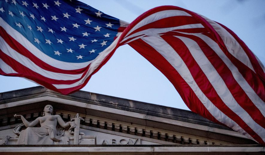 In this March 22, 2019 file photo, an American flag flies outside the Department of Justice in Washington.  (AP Photo/Andrew Harnik)