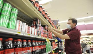 Store manager Donny Price restocks cans of Coke on the shelves at Gerrity&#39;s in Hanover Township, Pa., Tuesday, July 14, 2020. Area shoppers are encountering challenges getting certain soda and beer brands because of a national aluminum can shortage. Coca-Cola, for example, isn&#39;t producing 12-packs of cans of its Minute Maid Light Lemonade so it can meet the high demand of its more popular brands like Coca-Cola and Sprite as more people have been buying canned beverages during the COVID-19 pandemic. (Mark Moran/The Citizens&#39; Voice via AP) ** FILE **