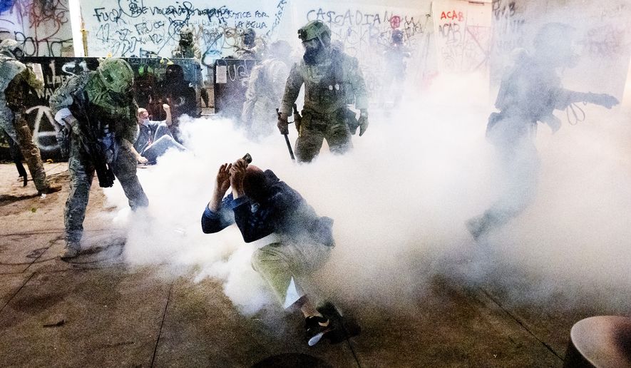 Federal officers use chemical irritants and crowd control munitions to disperse Black Lives Matter protesters outside the Mark O. Hatfield United States Courthouse on Wednesday, July 22, 2020, in Portland, Ore. (AP Photo/Noah Berger)