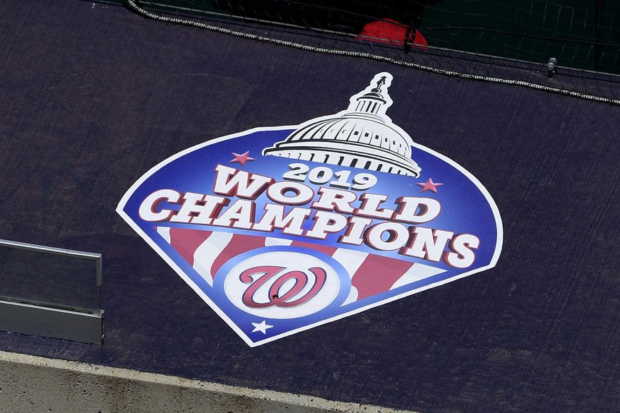 A 2019 World Series champions logo displayed is seen on the top of the dugout during the Washington Nationals baseball practice at Nationals Park, Wednesday, July 22, 2020, in Washington. (AP Photo/Nick Wass)