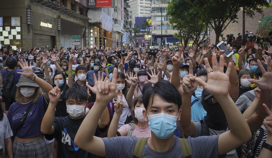 In this Wednesday, July. 1, 2020, file photo, protesters against the new national security law gesture with five fingers, signifying the &amp;quot;Five demands - not one less&amp;quot; on the anniversary of Hong Kong&#39;s handover to China from Britain in Hong Kong. Britain’s government has announced that it will open a new special pathway to obtaining U.K. citizenship for eligible Hong Kongers from January 2021. The Home Office said Wednesday, July 22, 2020, that holders of the British National Overseas passport and their immediate family members can move to the U.K. to work and study. (AP Photo/Vincent Yu, File)
