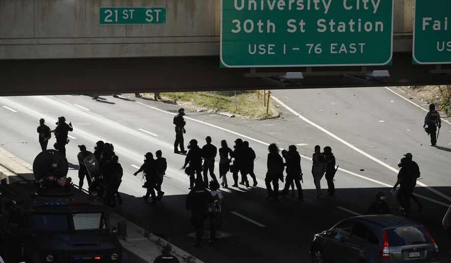 FILE—In this file photo from June 1, 2020, protesters march down Interstate 676 in Philadelphia, during a march calling for justice over the death of George Floyd.  The Philadelphia district attorney has announced Wednesday, July 22, charges against a police officer seen on video lowering the masks of protesters to douse them with pepper spray as they knelt on the highway during a protest on June 1.  (AP Photo/Matt Rourke, File)