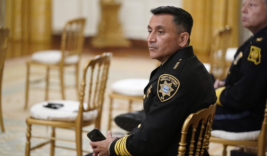 Bernalillo County Sheriff Manuel Gonzales, left, and Kansas City police Chief Rick Smith, wait for an event on "Operation Legend: Combatting Violent Crime in American Cities," to begin in the East Room of the White House, Wednesday, July 22, 2020, in Washington. (AP Photo/Evan Vucci)