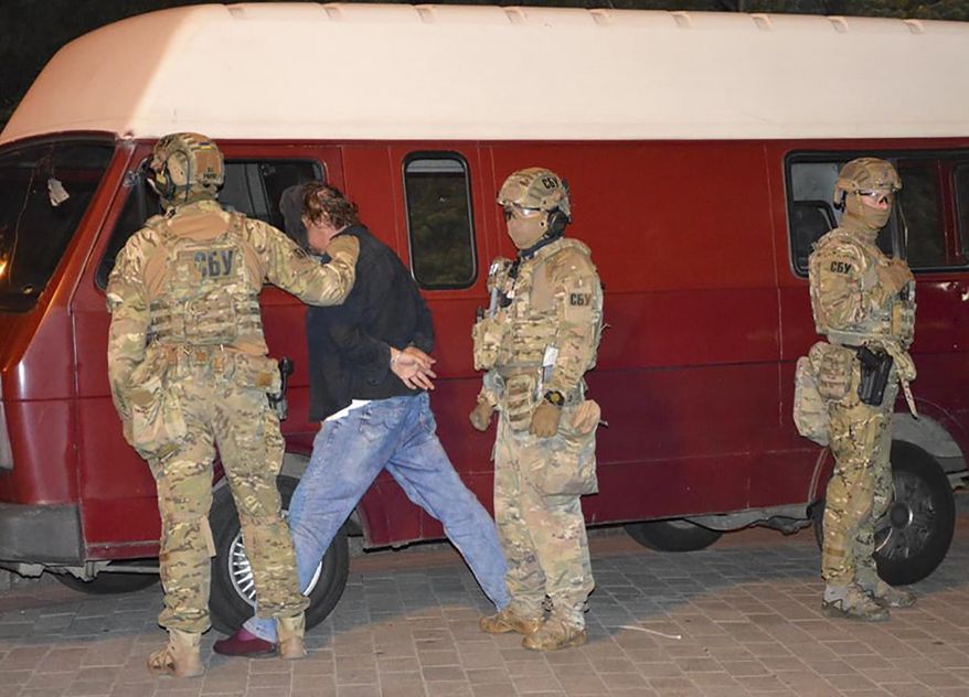 An assailant, who has seized a long-distance bus with 13 hostages, after police officers captured him in the city centre of Lutsk, some 400 kilometers (250 miles) west of Kyiv, Ukraine, on Tuesday late, July 21, 2020. Ukrainian police say the armed man who seized hostages on a long-distance bus in the western city of Lutsk has been detained and all the people he held have been freed unharmed after a standoff that lasted more than 12 hours. (Ukrainian Police Press Office via AP)