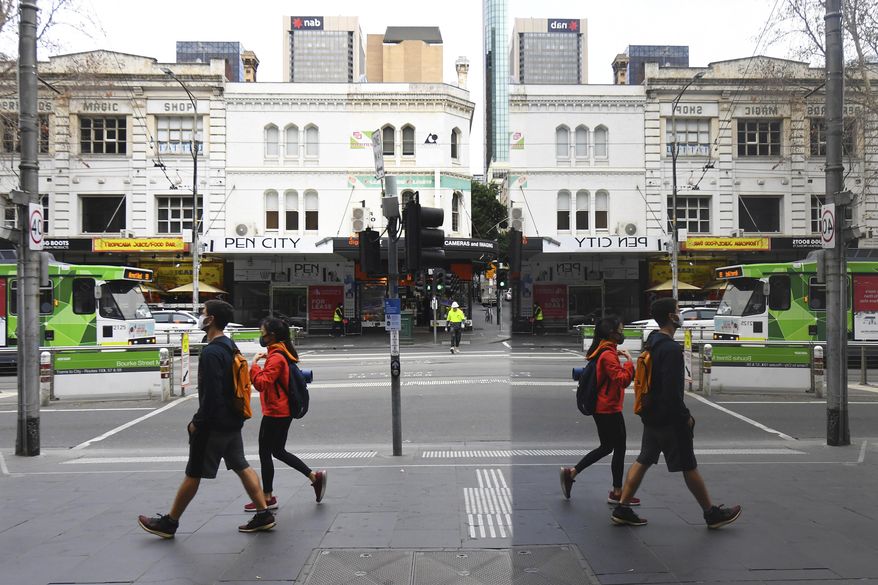 People wearing face masks to help protect against the spread of the new coronavirus walk in the central business district in Melbourne, Australia, Wednesday, July 22, 2020. Australia’s hard-hit Victoria state reported a record new COVID-19 cases on Wednesday and health authorities warned that numbers could continue to rise. With Australia’s second-largest city Melbourne now in lockdown for two weeks, authorities had hoped the infection rate would begin to plateau. (James Ross/AAP Image via AP)