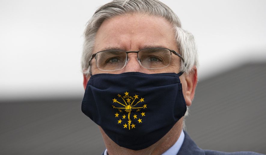 FILE - In this Thursday, April 30, 2020 file photo, Gov. Eric Holcomb wears a mask in Kokomo, Ind. Indiana will have a statewide face mask mandate starting next week, joining many other states in the attempt to slow the spread of the coronavirus. Gov. Eric Holcomb said Wednesday, July 22, 2020, the order will apply to anyone ages 8 and older in any indoor public or business areas and at outdoor public spaces when sufficient distancing can&#x27;t be maintained. The order will take effect Monday July 27. (AP Photo/Michael Conroy, File)