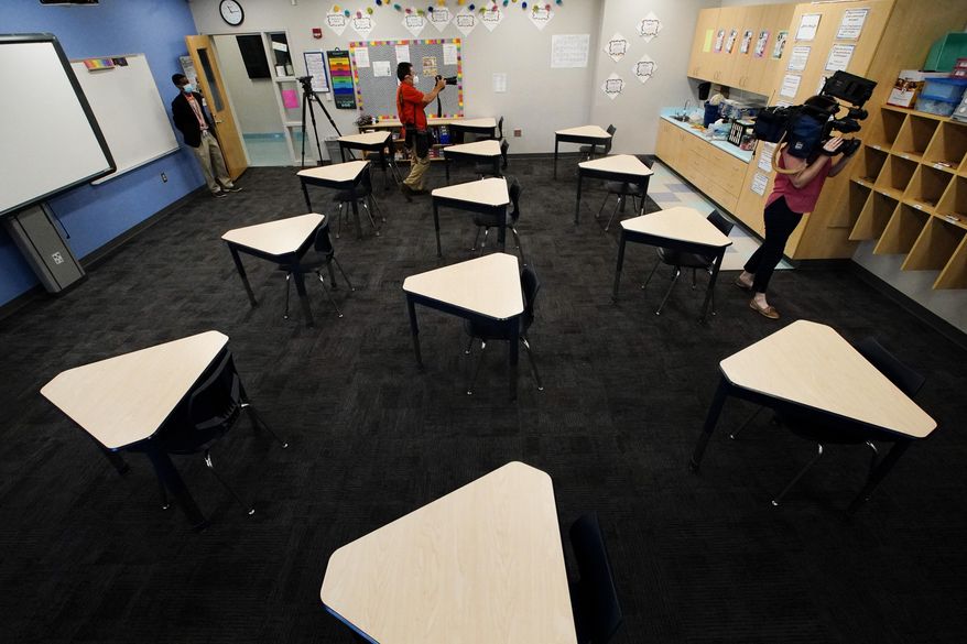 Media members document the inside of a fifth grade classroom set up for social distancing during a media demonstration at A.J. Whittenberg Elementary School of Engineering Monday, July 20, 2020, in Greenville, S.C. (AP Photo/Chris Carlson)