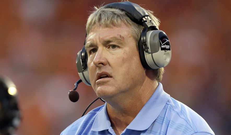 FILE - In this Sept. 27, 2014, file photo, Vic Koenning, at the time the defensive coordinator at North Carolina, watches during the first half of the team's NCAA college football game against Clemson in Clemson, S.C. West Virginia has parted ways with defensive coordinator Vic Koenning a month after safety Kerry Martin alleged he made a series of insensitive remarks, including against Hispanics. (AP Photo/Bob Leverone, File)