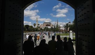 Visitors walk towards the Byzantine-era Hagia Sophia, in the historic Sultanahmet district of Istanbul, Saturday, July 11, 2020. Turkish President Recep Tayyip Erdogan is scheduled to join hundreds of worshipers Friday, July 24, for the first Muslim prayers at the Hagia Sophia in 86 years, weeks after a controversial high court ruling paved the way for the landmark monument to be turned back into a mosque. (AP Photo/Emrah Gurel)