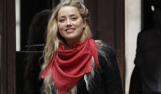 American actress Amber Heard smiles at the media as she arrives at the High Court in London, Thursday, July 23, 2020. Actor Johnny Depp is suing News Group Newspapers, publisher of The Sun, and the paper&#39;s executive editor, Dan Wootton, over an April 2018 article that called him a &amp;quot;wife-beater.&amp;quot;  Depp strongly denies all allegations.(AP Photo/Matt Dunham)