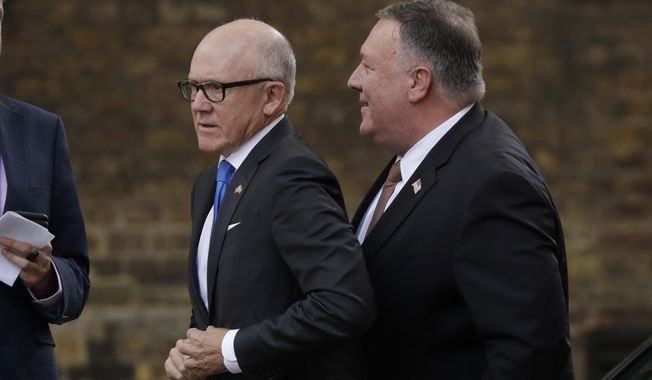 U.S. Secretary of State Mike Pompeo, right, passes Woody Johnson the U.S. Ambassador to Britain as he walks to 10 Downing Street in London, for his meeting with British Prime Minister Boris Johnson, Tuesday, July 21, 2020. (AP Photo/Matt Dunham)
