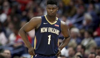 FILE - In this March 6, 2020, file photo, New Orleans Pelicans forward Zion Williamson walks onto the court during the second half of the team&#39;s NBA basketball game against the Miami Heat in New Orleans. The rookie sensation’s availability to play remained unclear as the season’s resumption in Lake Buena Vista, Florida, approached. He left the NBA’s so-called “bubble” setup on July 16 to attend to an unspecified family medical matter. A week later, the club had yet to provide an update on his possible return.  (AP Photo/Rusty Costanza, File)