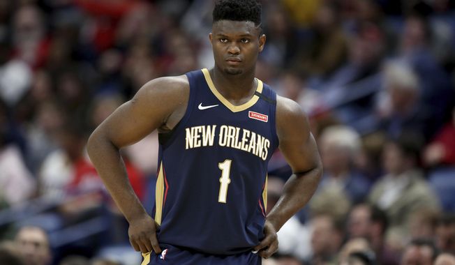 FILE - In this March 6, 2020, file photo, New Orleans Pelicans forward Zion Williamson walks onto the court during the second half of the team&#x27;s NBA basketball game against the Miami Heat in New Orleans. The rookie sensation’s availability to play remained unclear as the season’s resumption in Lake Buena Vista, Florida, approached. He left the NBA’s so-called “bubble” setup on July 16 to attend to an unspecified family medical matter. A week later, the club had yet to provide an update on his possible return.  (AP Photo/Rusty Costanza, File)