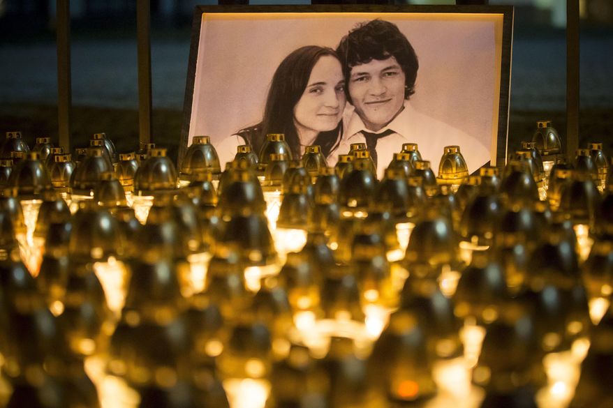 FILE - In this Wednesday, Feb. 28, 2018 file photo, light tributes are seen during a silent protest in memory of murdered journalist Jan Kuciak and his girlfriend Martina Kusnirova, seen in photo, in Bratislava, Slovakia. The state prosecutor in Slovakia requested on Thursday, July 23, 2020 a 25-year prison term for all three defendants in the alleged contract killings of an investigative journalist and his fiancee, a case that triggered a political crisis and brought down the country’s government. (AP Photo/Bundas Engler, file)