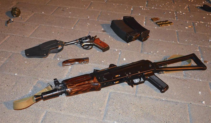 Weapon that belonged to an assailant, who seized a long-distance bus with 13 hostages, on the ground after police officers captured the assailant in the city centre of Lutsk, some 400 kilometers (250 miles) west of Kyiv, Ukraine late Tuesday July 21, 2020. Ukrainian police say the armed man who seized hostages aboard a long-distance bus in the western city of Lutsk has been detained and all the people he held have been freed unharmed after a standoff that lasted more than 12 hours. (Ukrainian Police Press Office via AP)