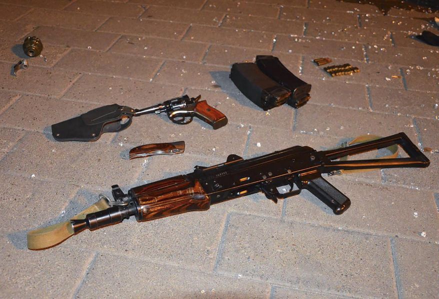 Weapon that belonged to an assailant, who seized a long-distance bus with 13 hostages, on the ground after police officers captured the assailant in the city centre of Lutsk, some 400 kilometers (250 miles) west of Kyiv, Ukraine late Tuesday July 21, 2020. Ukrainian police say the armed man who seized hostages aboard a long-distance bus in the western city of Lutsk has been detained and all the people he held have been freed unharmed after a standoff that lasted more than 12 hours. (Ukrainian Police Press Office via AP)
