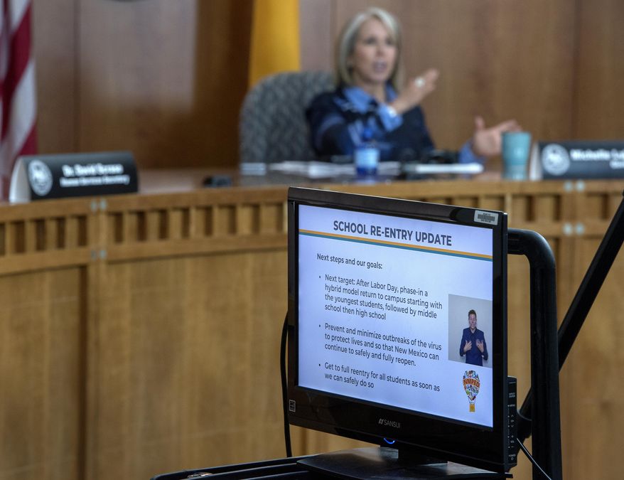 New Mexico Gov. Michelle Lujan Grisham announces public schools must go to a distance-learning program to start the school year. She made the announcement during an update on COVID-19 broadcast from the state Capitol in Santa Fe, N.M., on Thursday, July 23, 2020. (Eddie Moore/The Albuquerque Journal via AP)
