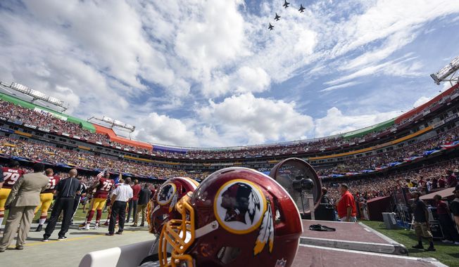 FILE - In this Sept. 18, 2016, file photo, F-26 fighter jets from the DC Air National Guard fly over FedEx Field before an NFL football game against between the Washington Redskins and the Dallas Cowboys in Landover, Md. A person with knowledge of the move tells The Associated Press the team formerly known as Redskins will go by Washington Football Team until a new name is chosen. Washington will keep its burgundy and gold colors and replace the Indian head logo on helmets with a player&#x27;s jersey number.  (AP Photo/Nick Wass, File)