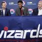In this June 21, 2019, file photo, the Washington Wizards draft pick Rui Hachimura, of Japan, center, smiles during an introductory press conference with head coach Scott Brooks, left, and Senior Vice President of Basketball Operations Tommy Sheppard at Capital One Arena in Washington.  The Washington Wizards won’t have Bradley Beal, John Wall or Davis Bertans when the NBA returns amid the coronavirus pandemic. That leaves a bunch of young players, led by rookie Rui Hachimura, the first Japanese player to be taken in the first round of the NBA draft. (AP Photo/Pablo Martinez Monsivais, File) **FILE**