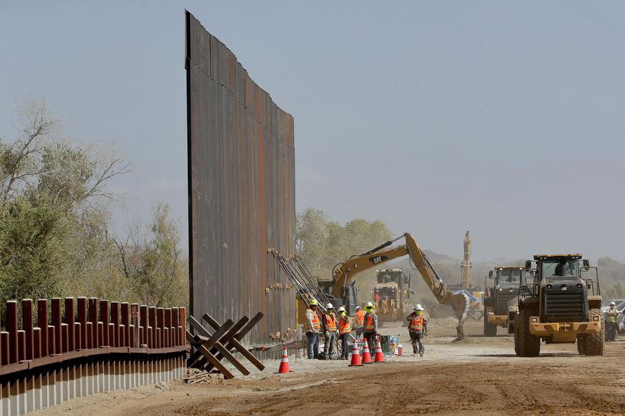 In this Sept. 10, 2019 file photo government contractors erect a section of Pentagon-funded border wall along the Colorado River in Yuma, Ariz. The federal Bureau of Land Management said on Tuesday, July 21, 2020, it's transferred over 65 acres of public land in Arizona and New Mexico to the Army for construction of border wall infrastructure. (AP Photo/Matt York, File)