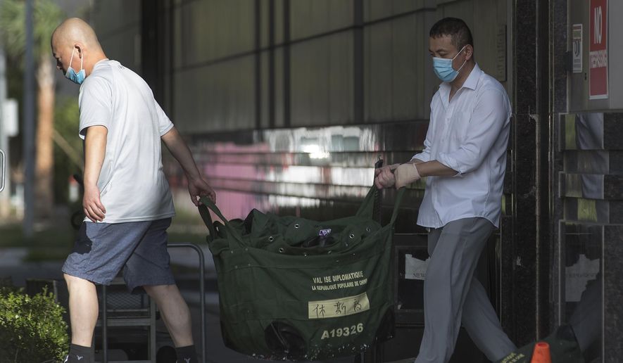 In this file photo, consulate workers carry diplomatic bags from the Consulate General of China Friday, July 24, 2020, in Houston.  The U.S.government has ordered the Houston consulate to close by Friday. (Brett Coomer/Houston Chronicle via AP)   **FILE**