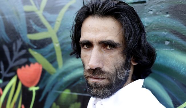 FILE - In this Nov. 19, 2019, file photo, Behrouz Boochani, the Kurdish film-maker, writer and refugee who has documented life inside the Australian offshore immigration camp on Manus Island, poses for a portrait in Christchurch, New Zealand. New Zealand immigration on Friday confirmed that Boochani, who fled Iran and then exposed Australia’s degrading treatment of asylum-seekers while being held against his will for six years, has been granted refugee status in New Zealand. (AP Photo/Mark Baker, File)